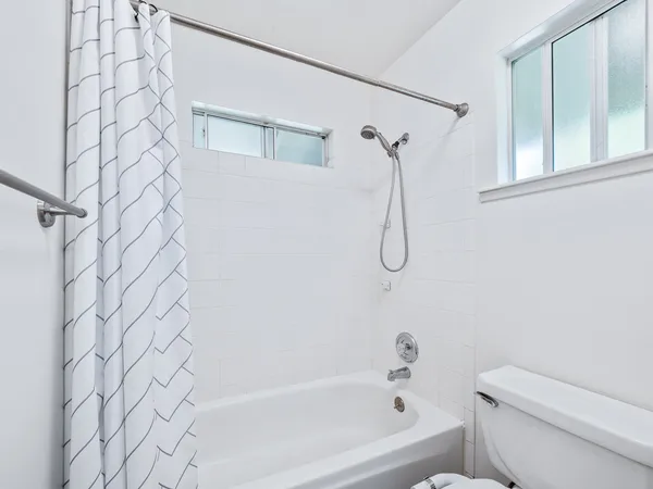 a bathroom with a shower curtain and a toilet