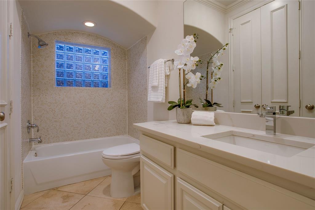 3810 Hawthorne Avenue Dallas, TX 75219 - Photo 11 of 40 a bathroom with a granite countertop sink a toilet and a bathtub