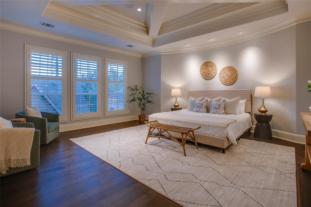 3810 Hawthorne Avenue Dallas, TX 75219 - Photo 32 of 40 a bedroom with a large bed and wooden floor