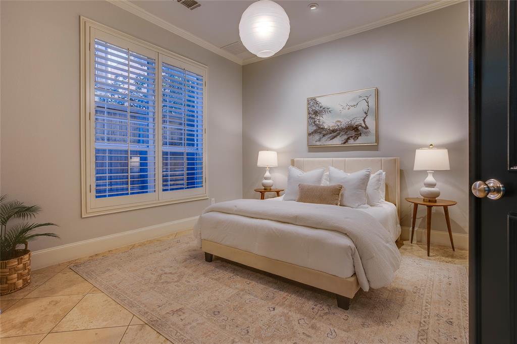 3810 Hawthorne Avenue Dallas, TX 75219 - Photo 9 of 40 a spacious bedroom with a bed and a painting on the wall