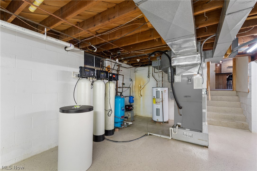 22840 Buck Road Alliance, OH 44601 - Photo 20 of 36 Unfinished basement with a water softener, electric water heater, a water pressure tank, and heating unit