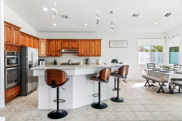 a kitchen with stainless steel appliances granite countertop a sink a stove and a refrigerator