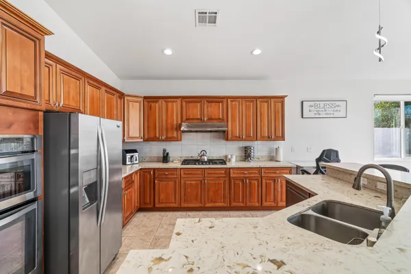 a kitchen with stainless steel appliances granite countertop a sink stove and refrigerator