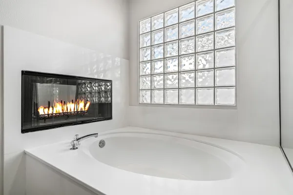 a white bath tub sitting in a bathroom next to a window
