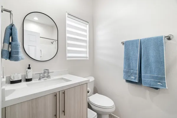 a bathroom with a toilet a sink a vanity and mirror