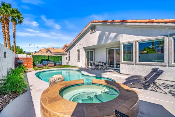 a view of a house with swimming pool and porch with furniture