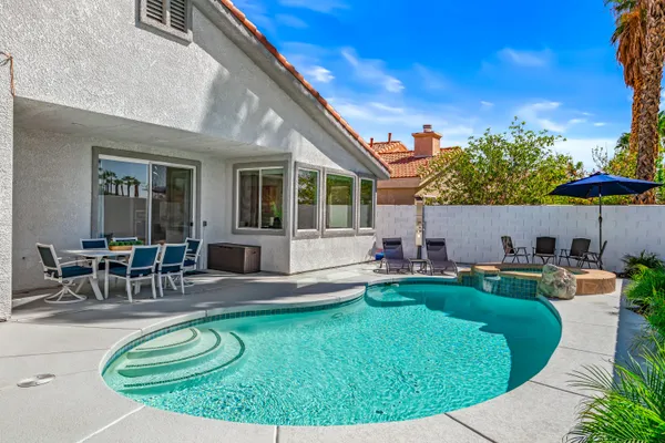 a view of a house with swimming pool and sitting area