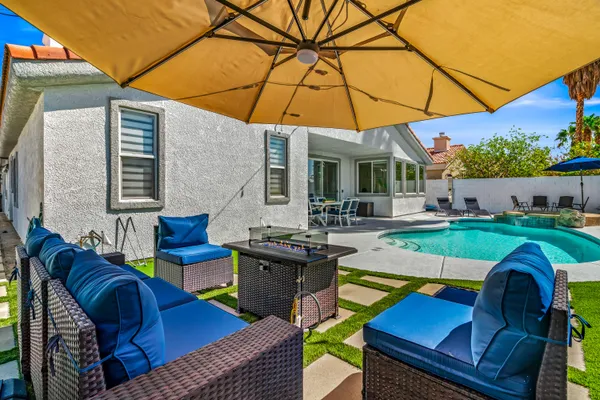 a view of an outdoor sitting area with furniture and umbrella