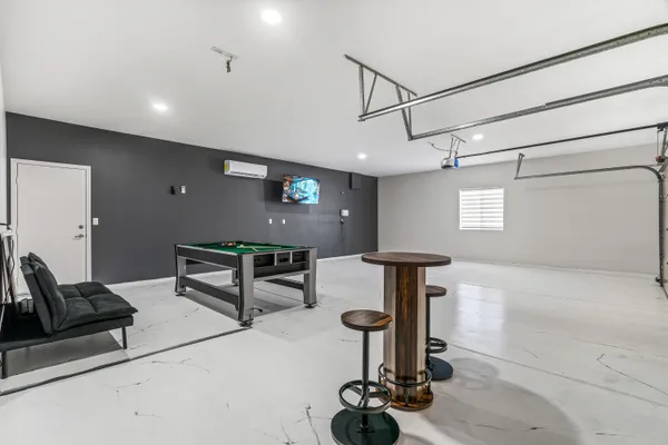a room with pool table and windows