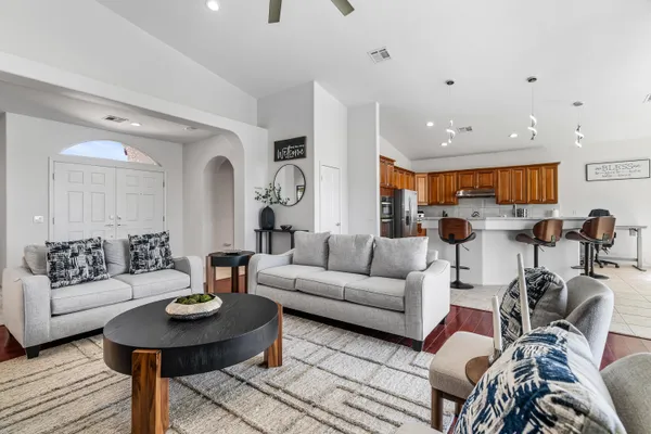 a living room with furniture kitchen view and a table