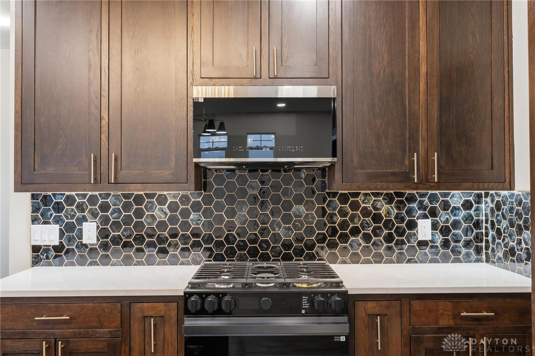 3509 South State Rte 72 Sabina, OH 45169 - Photo 16 of 44 This modern kitchen features rich cabinetry, a sleek gas range, and eye-catching hexagonal tile backsplash.