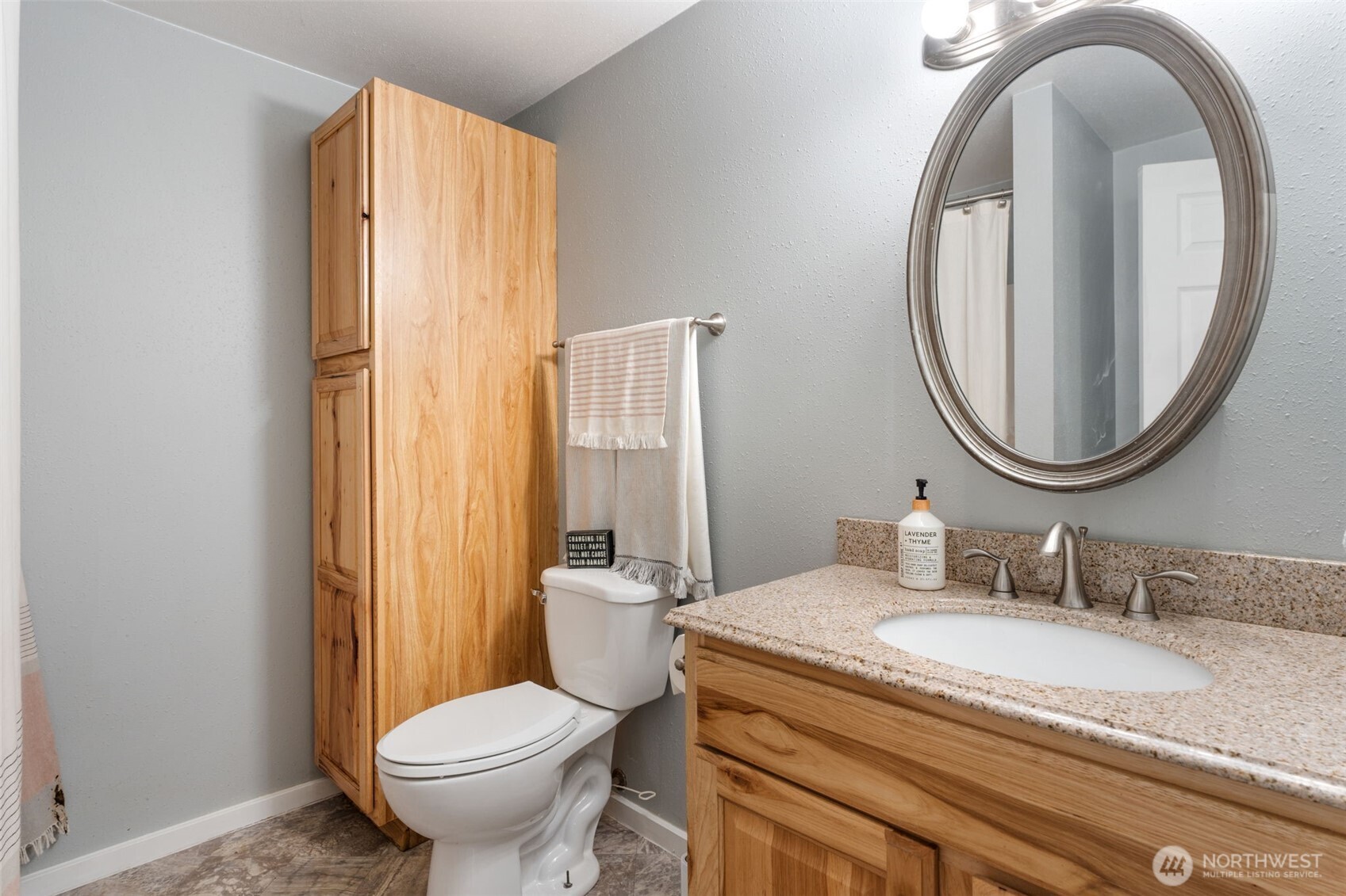 2163 Wildwood Road Curtis, WA 98538 - Photo 9 of 36 a bathroom with a granite countertop toilet a sink and a mirror