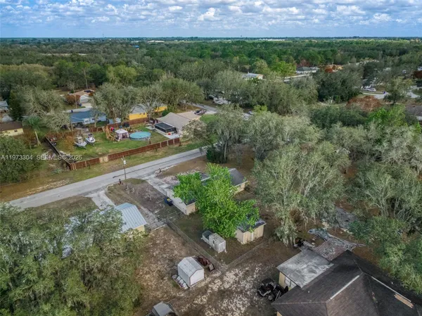 an aerial view of residential houses with outdoor space and lake view