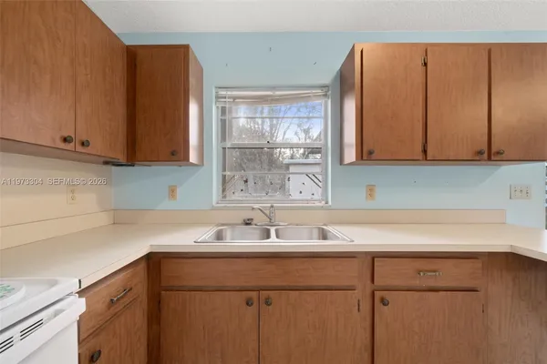 a kitchen with a sink cabinets and a window