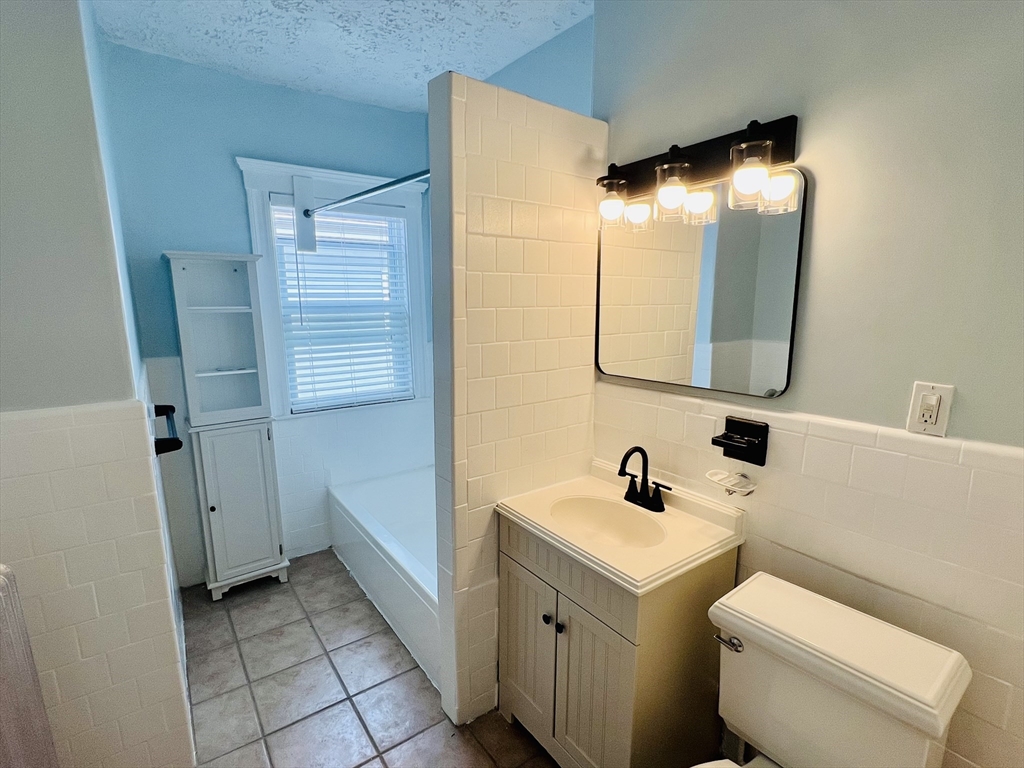 62 Westmore Road, Unit 2 Boston, MA 02126 - Photo 12 of 13 a bathroom with a sink a toilet and mirror