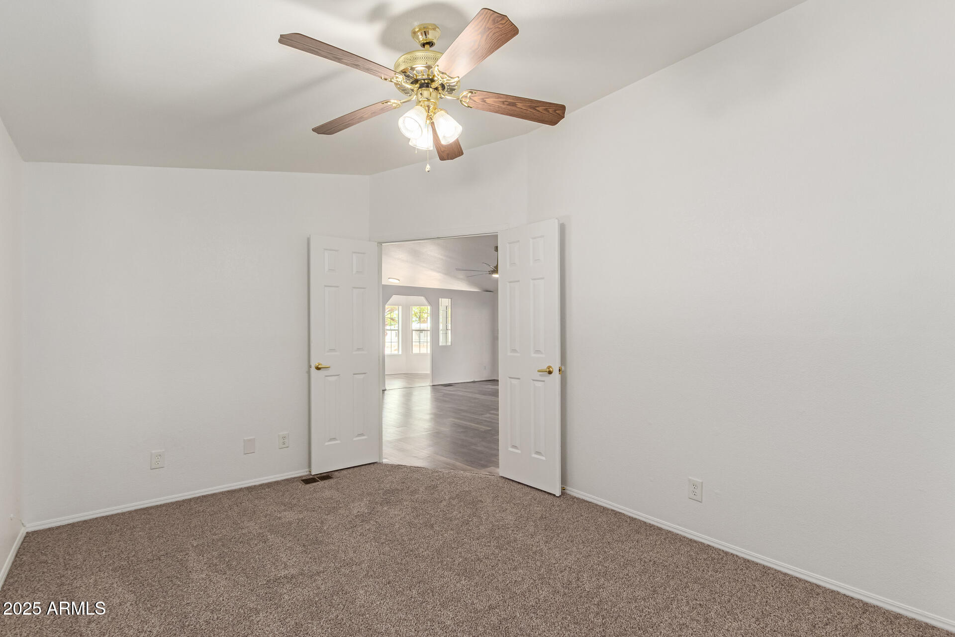 2311 South Descanso Road Apache Junction, AZ 85119 - Photo 15 of 35 an empty room with a chandelier fan and windows