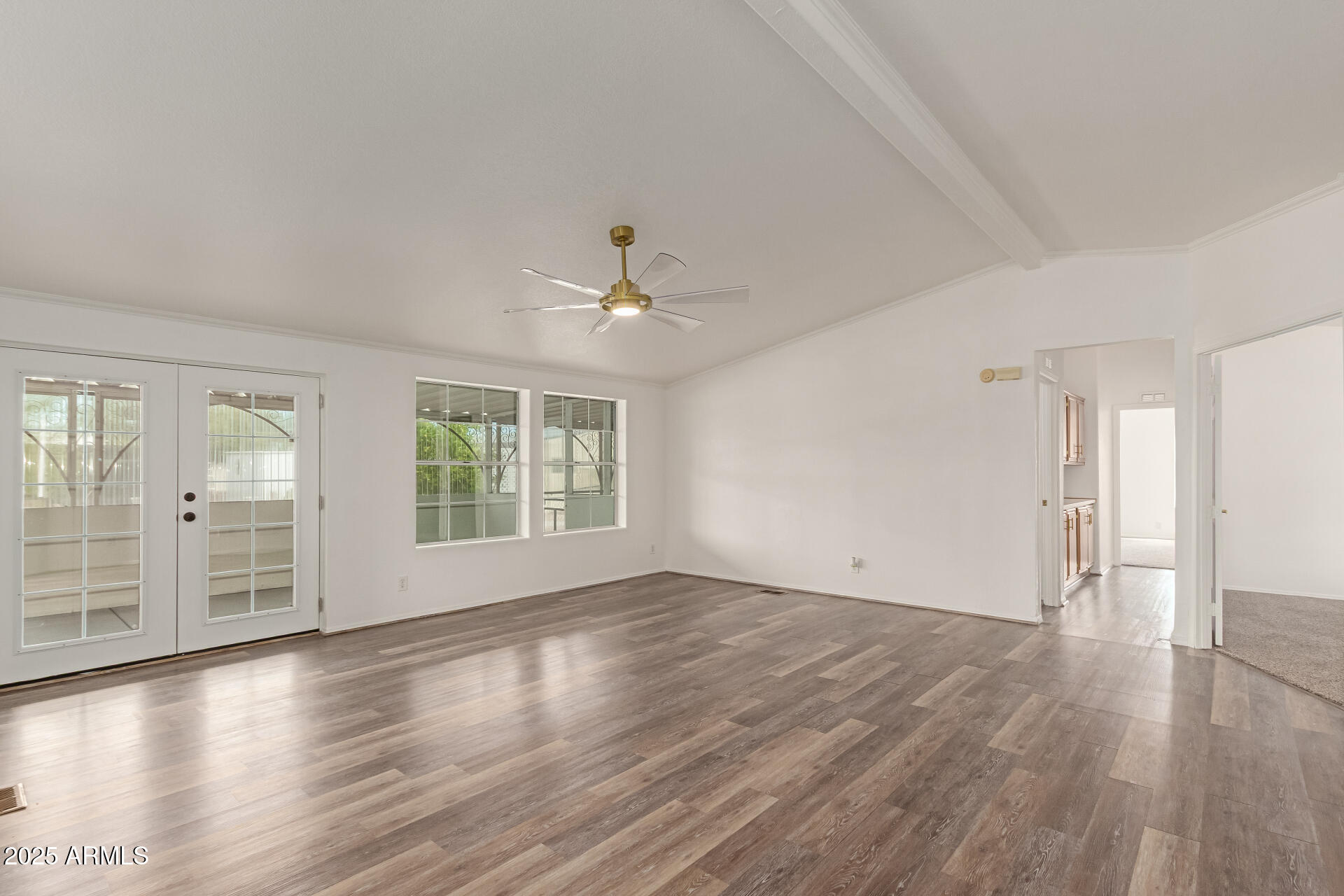 2311 South Descanso Road Apache Junction, AZ 85119 - Photo 6 of 35 an empty room with wooden floor and windows