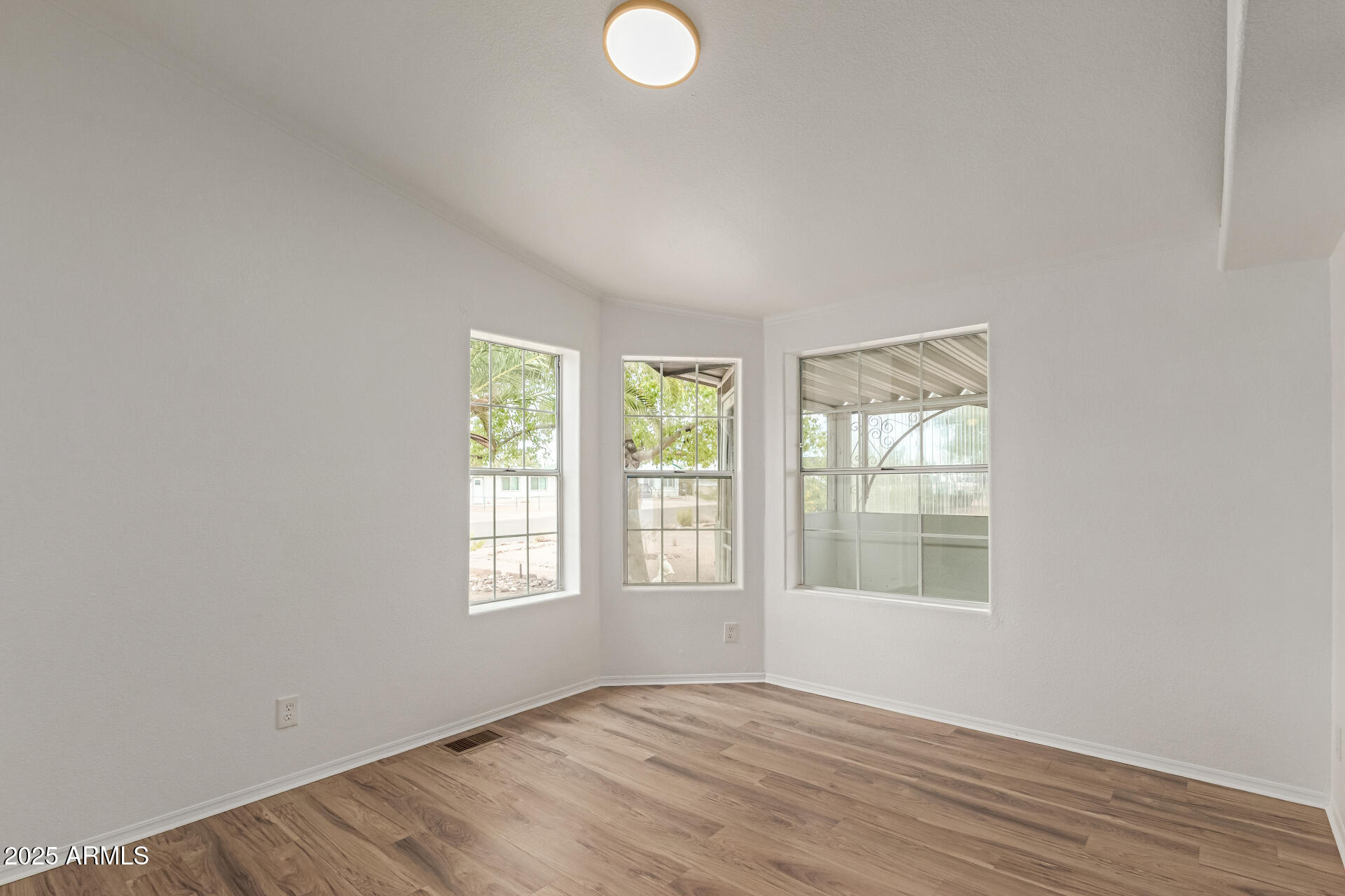 2311 South Descanso Road Apache Junction, AZ 85119 - Photo 7 of 35 an empty room with wooden floor and windows