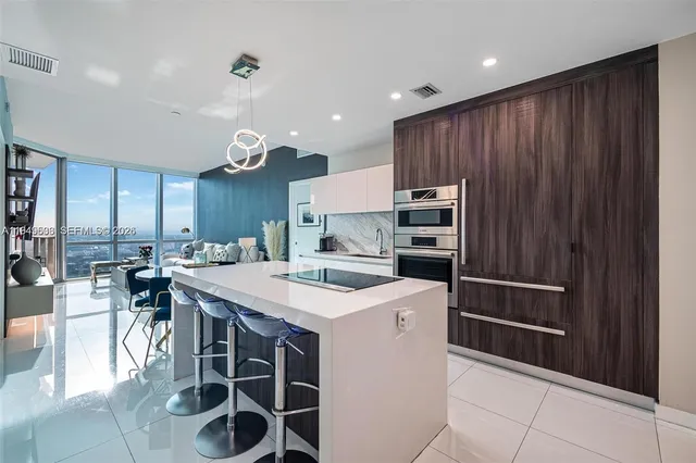 a kitchen with a sink a counter space appliances and cabinets