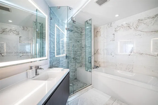 a bathroom with a granite countertop sink mirror toilet and bathtub