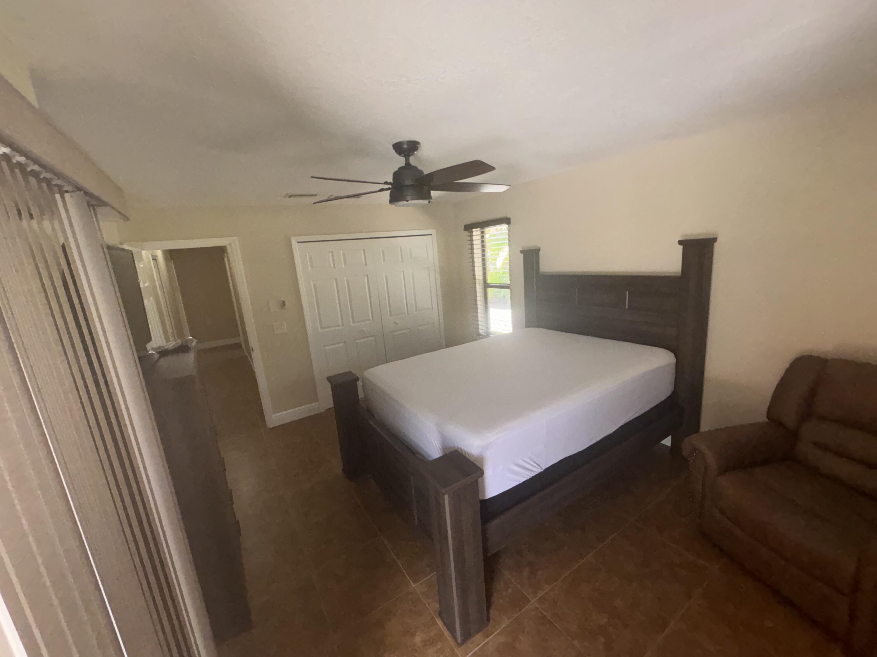 1257 Southeast Airoso Boulevard, Unit B Port St. Lucie, FL 34983 - Photo 12 of 12 a bedroom with a bed and a window