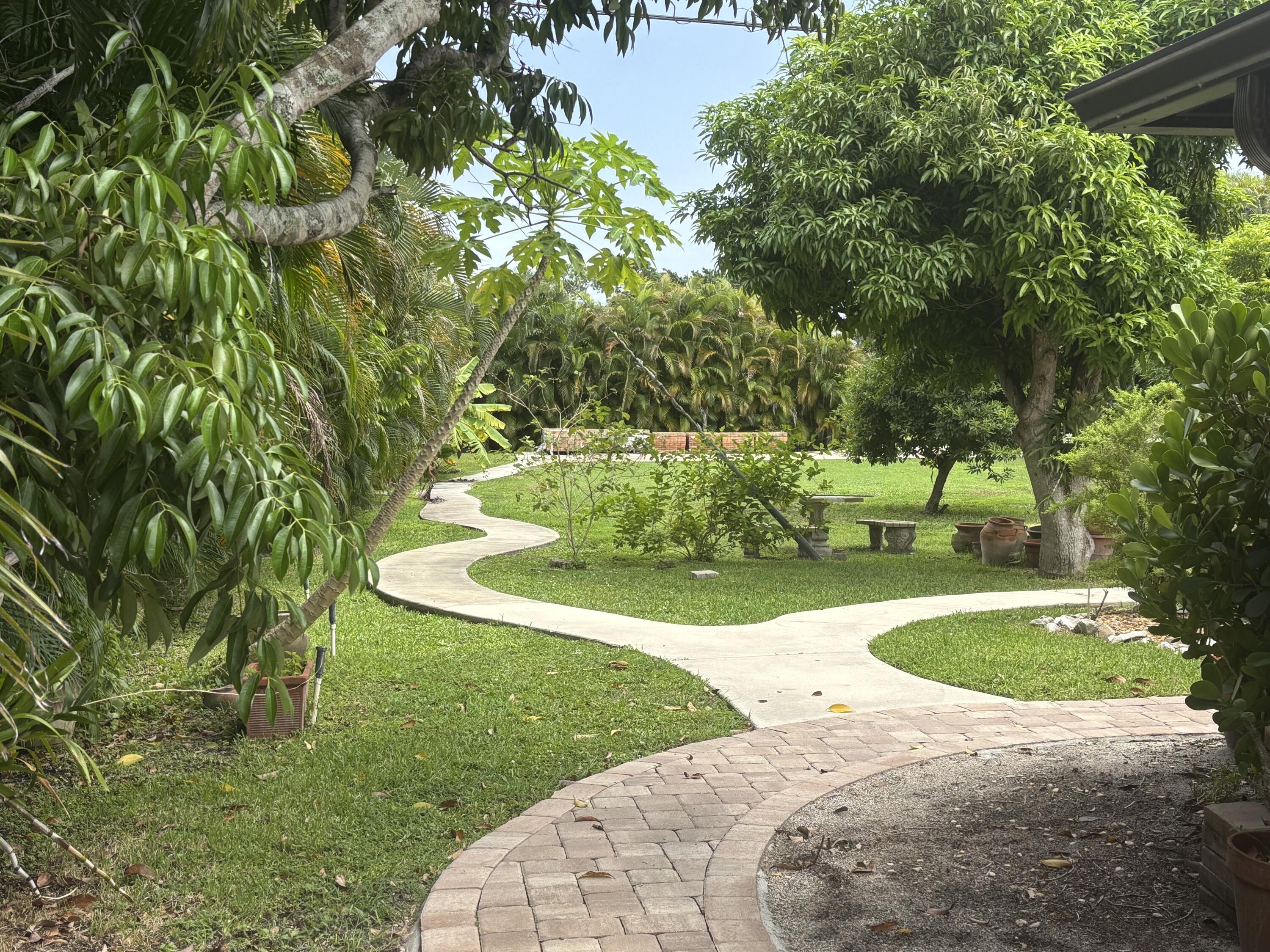1257 Southeast Airoso Boulevard, Unit B Port St. Lucie, FL 34983 - Photo 2 of 12 a view of a garden with a fountain