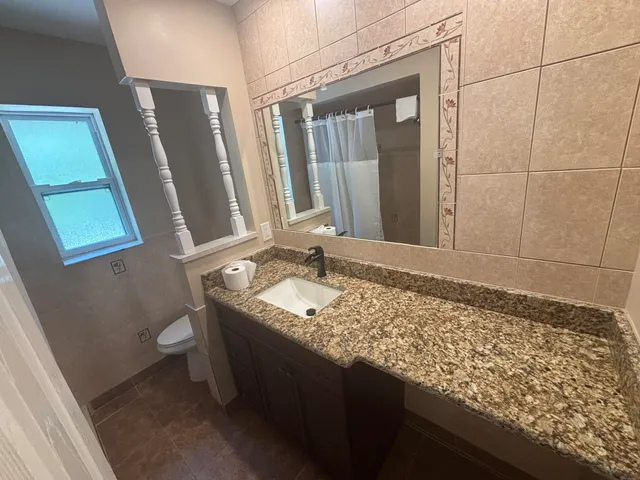 a bathroom with a granite countertop sink and a mirror