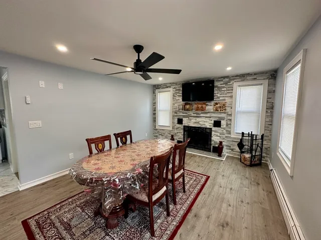 a dining room with furniture a fireplace and wooden floor