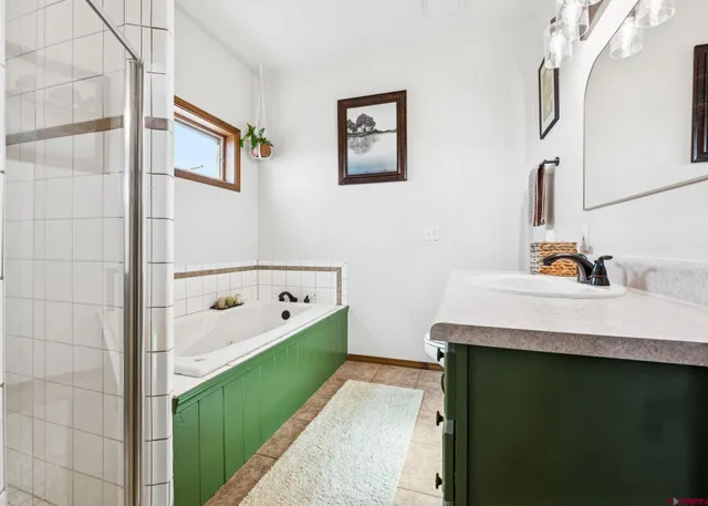 a bathroom with a tub sink and mirror