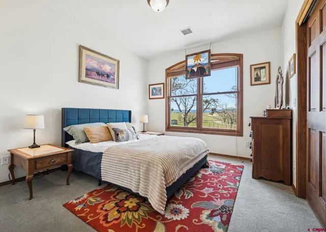a bedroom with a bed and a painting on the wall