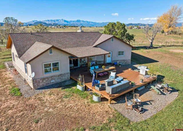 an aerial view of a house with swimming pool and furniture