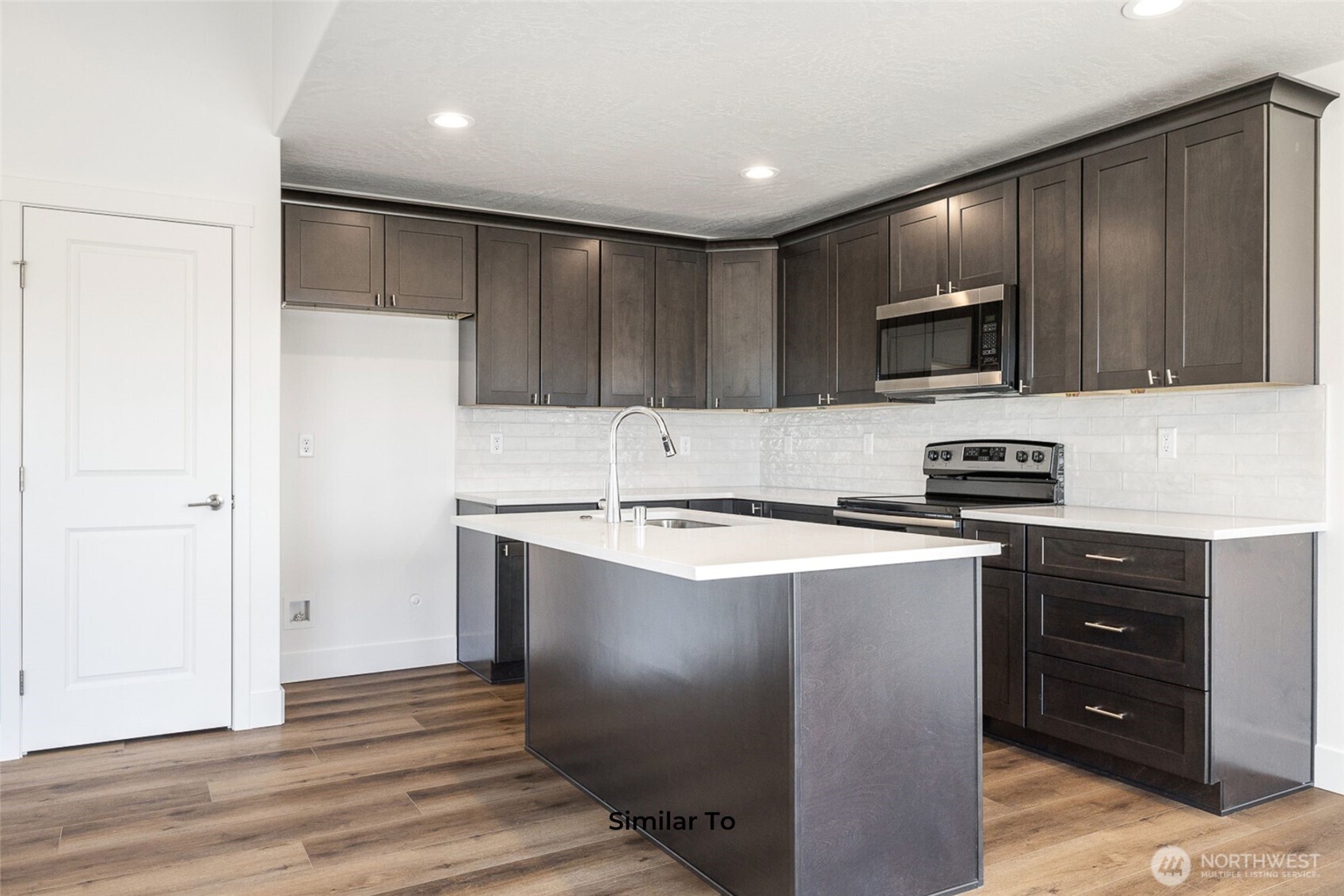 4251 Sandy Street Moses Lake, WA 98837 - Photo 11 of 19 a kitchen with stainless steel appliances granite countertop a stove a refrigerator and a microwave