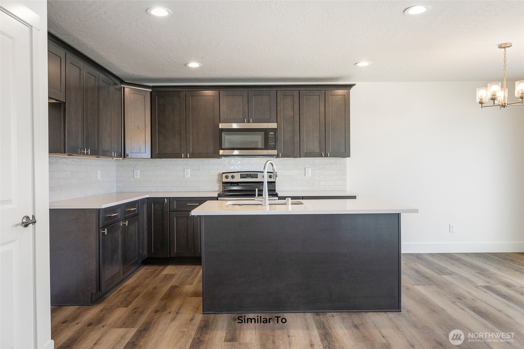 4251 Sandy Street Moses Lake, WA 98837 - Photo 12 of 19 a kitchen with stainless steel appliances granite countertop a stove a sink and a refrigerator