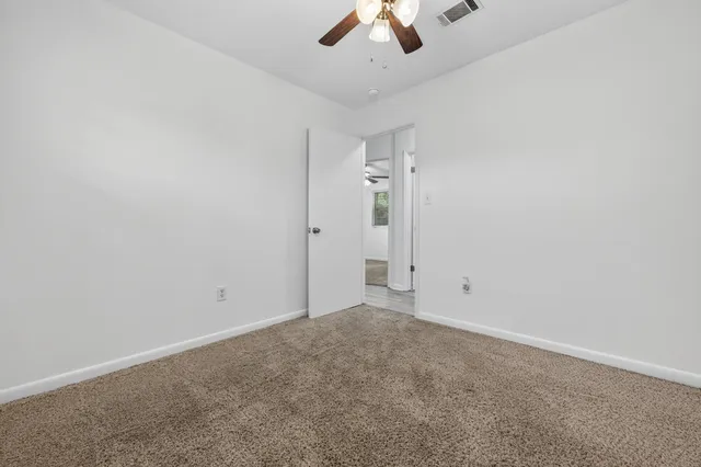 an empty room with a empty space and a ceiling fan