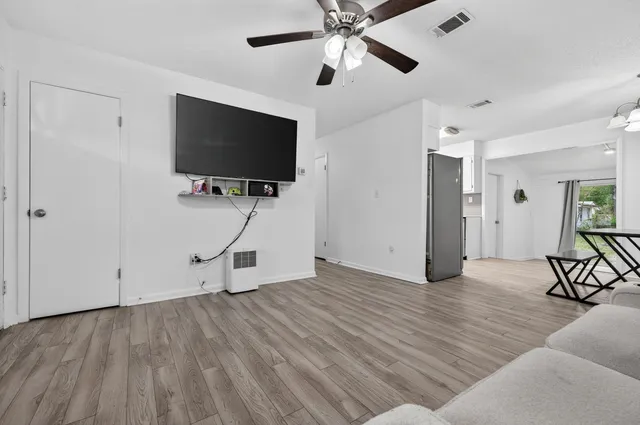 a living room with furniture and a wooden floor