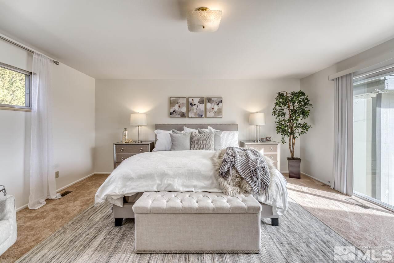 990 Yori Avenue Reno, NV 89502 - Photo 25 of 40 a spacious bedroom with a bed and a chandelier