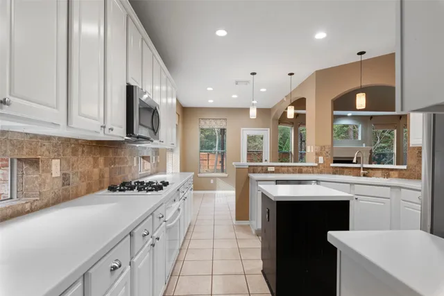 a kitchen with stainless steel appliances granite countertop a sink counter space cabinets and a large window