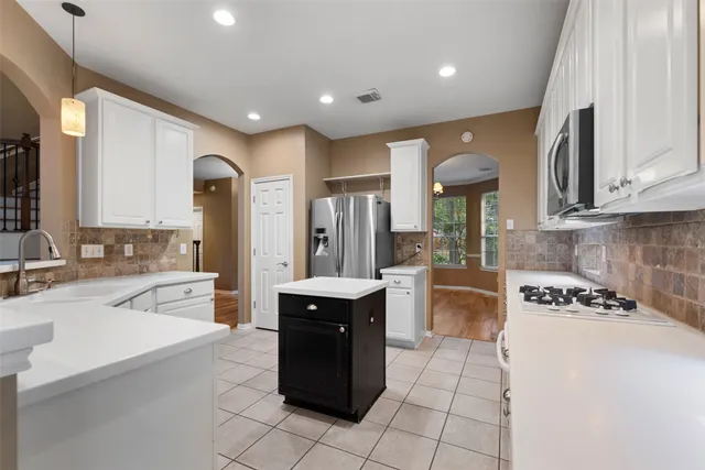 a open kitchen with a sink a stove a microwave and cabinets