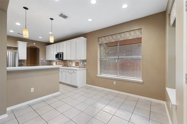 a view of an empty room with a fireplace and a window