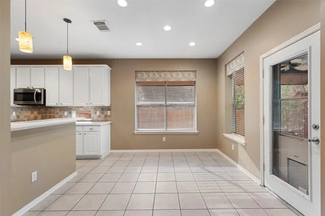 a view of an empty room with wooden floor fireplace and a window