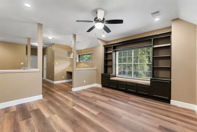 an empty room with wooden floor closet and ceiling fan