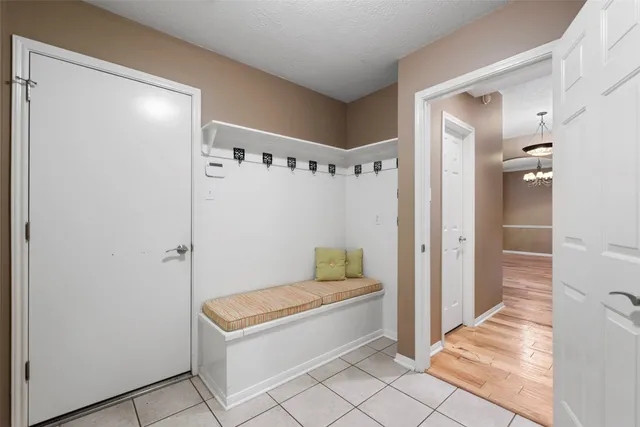 a view of a patio with a table and chairs under an umbrella with a small yard