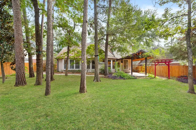 a view of a house with a small yard and a large tree
