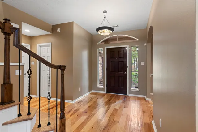 a view of a hallway with wooden floor and staircase