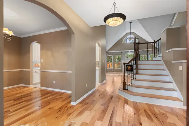 a view of a hallway with wooden floor and staircase