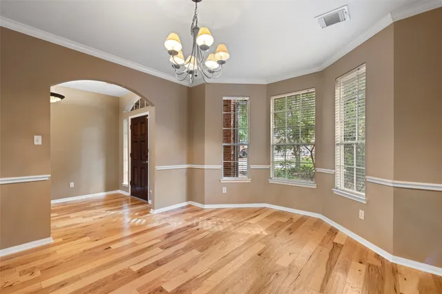 a view of a livingroom with a chandelier fan and windows