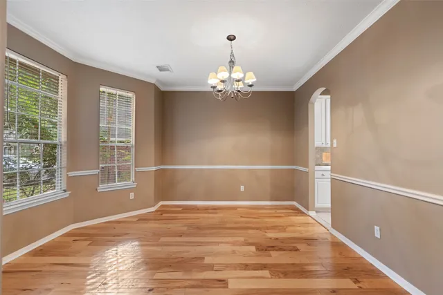 a view of a room with wooden floor and chandelier
