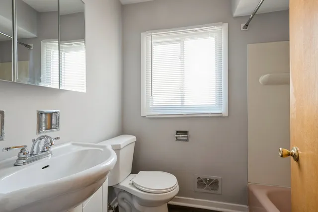 a bathroom with a sink a toilet and a mirror