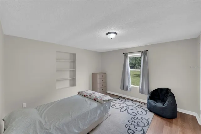 a bedroom with a bed and wooden floor