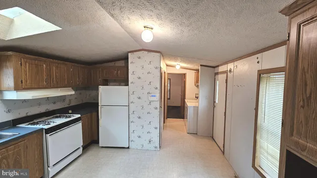 a kitchen with a refrigerator and a stove top oven